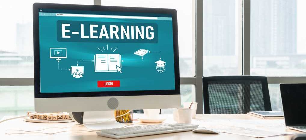 Apple Mac Computer am Bildschirm steht das Wort E-Learning Apple Mac Computer am Bildschirm steht das Wort E-Learning