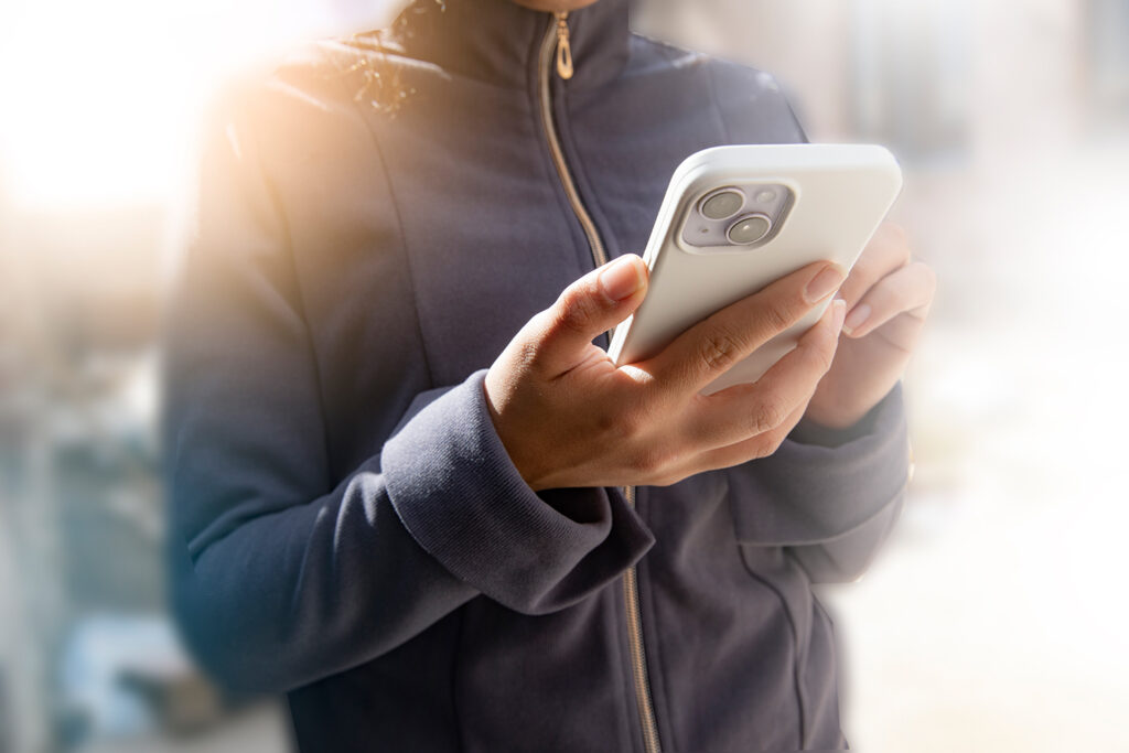 Junge Person mit großem Handy im Vordergrund